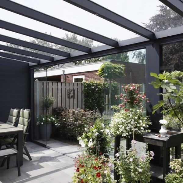 Sfeervolle antractiete terrasoverkapping met glaswanden, tuinset en planten