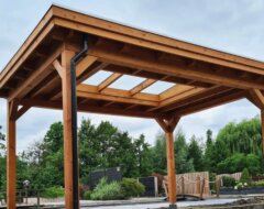 Vrijstaande houten overkapping met lichtstraat zadeldak in tuin