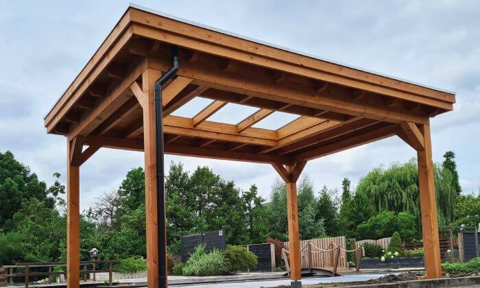 Vrijstaande houten overkapping met lichtstraat zadeldak in tuin