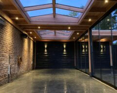 Terrsoverkapping muuraanbouw met dubbele zadeldak lichtstraat en antraciet glazen schuifwanden