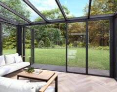 Moderne tuinkamer met visgraatvloer en glazen overkapping en glazen schuifwanden antraciet