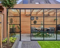 Houten overkapping met steel look glazen schuifwanden