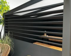 Danenberg Shop Louvres - Louvre zwart in zijwand terrasoverkapping i.c.m. Grillo schuttingpanelen